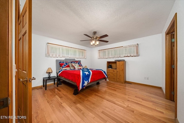 bedroom featuring a textured ceiling, ceiling fan, and light wood-type flooring