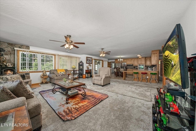 carpeted living room with ceiling fan and a textured ceiling