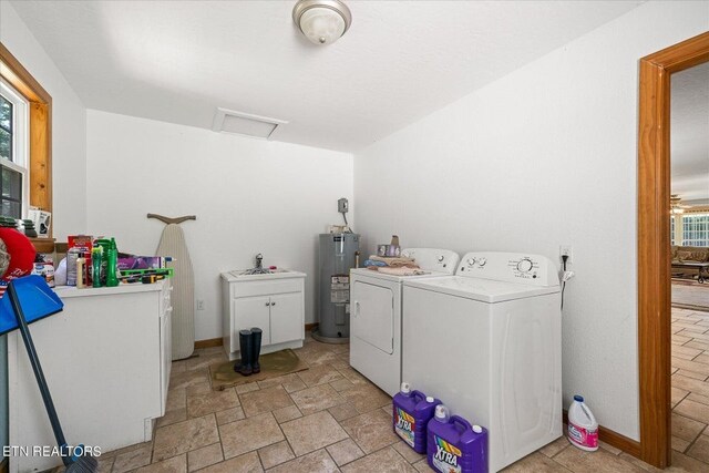 clothes washing area featuring washing machine and dryer, electric water heater, and light tile floors