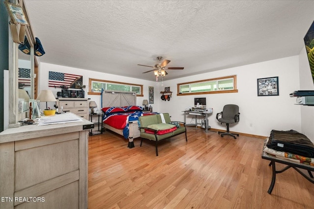 bedroom featuring light hardwood / wood-style floors, a textured ceiling, and ceiling fan