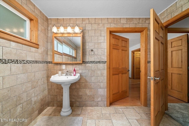 bathroom with tile walls, hardwood / wood-style flooring, and a textured ceiling