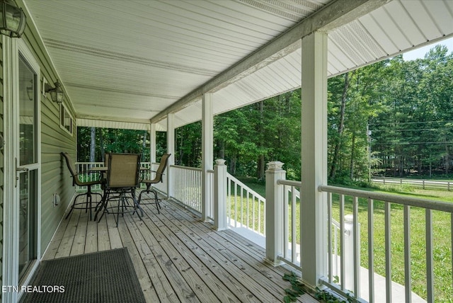 wooden terrace featuring a yard