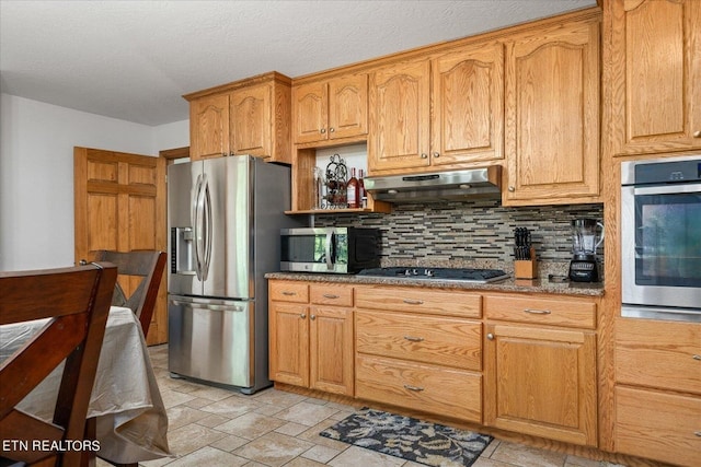 kitchen featuring stainless steel appliances, tasteful backsplash, stone countertops, and light tile floors