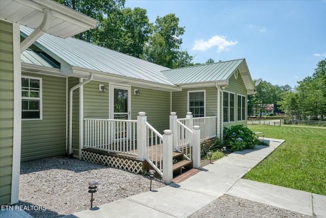 view of front of house with a deck and a front yard