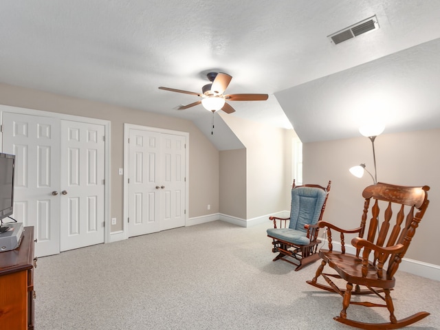 sitting room featuring a textured ceiling, carpet flooring, ceiling fan, and vaulted ceiling