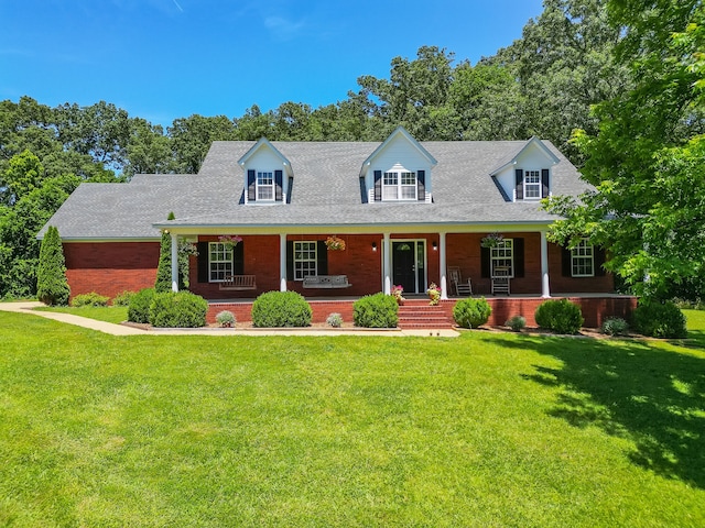 new england style home featuring a front lawn and a porch