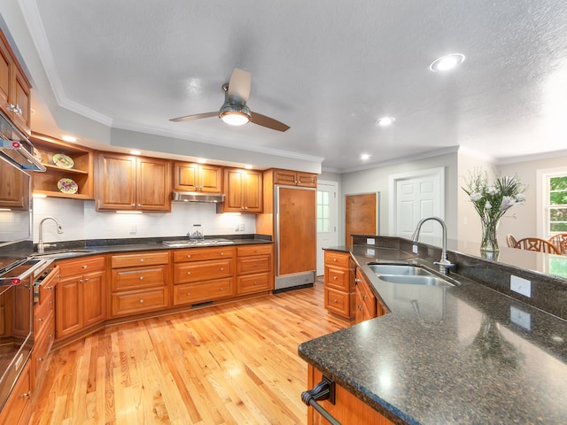 kitchen with light hardwood / wood-style floors, sink, ceiling fan, and stainless steel gas cooktop