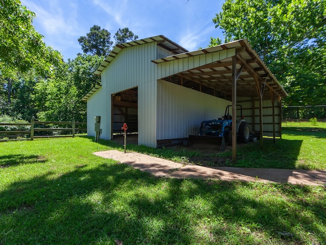 view of outdoor structure with a carport and a lawn