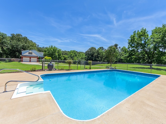 view of swimming pool with a yard