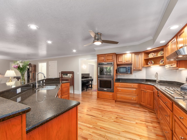 kitchen with stainless steel appliances, sink, ceiling fan, and light hardwood / wood-style floors