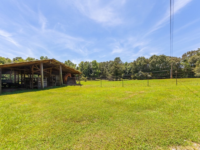 view of yard with an outdoor structure and a rural view