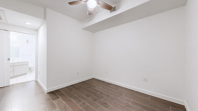 spare room with ceiling fan and dark wood-type flooring