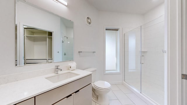 bathroom featuring tile patterned flooring, vanity, toilet, and a shower with door