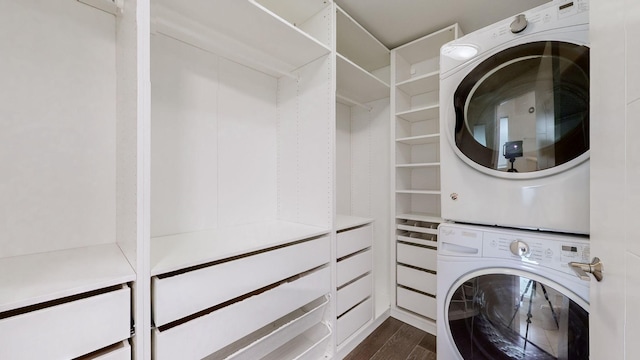 laundry area with dark hardwood / wood-style flooring and stacked washer / dryer