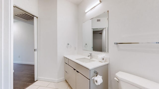 bathroom with tile patterned flooring, vanity, and toilet