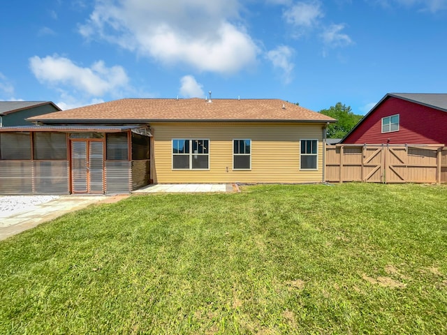 back of property with a lawn and a patio