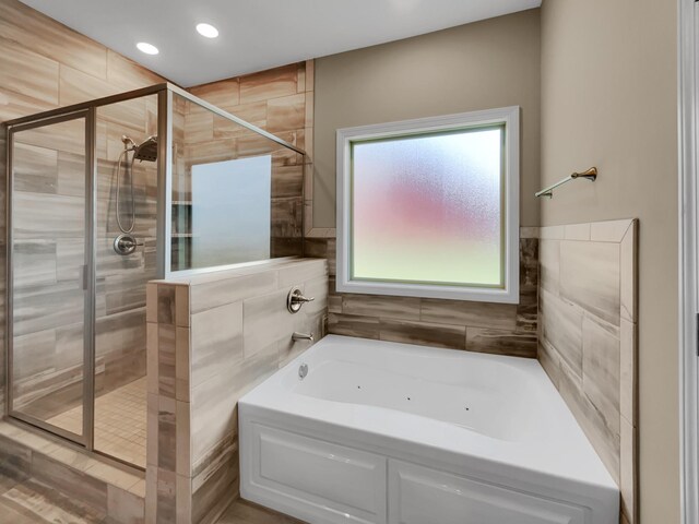 bathroom featuring shower with separate bathtub