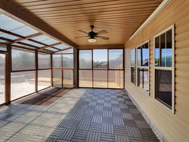 unfurnished sunroom featuring ceiling fan and wooden ceiling