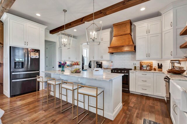 kitchen featuring premium range hood, white cabinets, stainless steel appliances, and beam ceiling