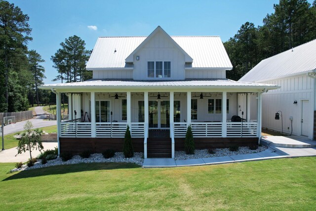 modern farmhouse with french doors, a front lawn, and covered porch