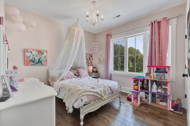 bedroom with hardwood / wood-style floors and a chandelier