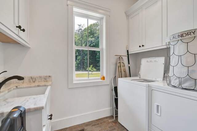 washroom featuring washing machine and clothes dryer, a healthy amount of sunlight, sink, and cabinets