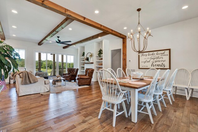 dining space featuring beam ceiling, light hardwood / wood-style flooring, and ceiling fan with notable chandelier