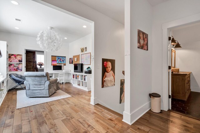 living area with light hardwood / wood-style flooring and a chandelier