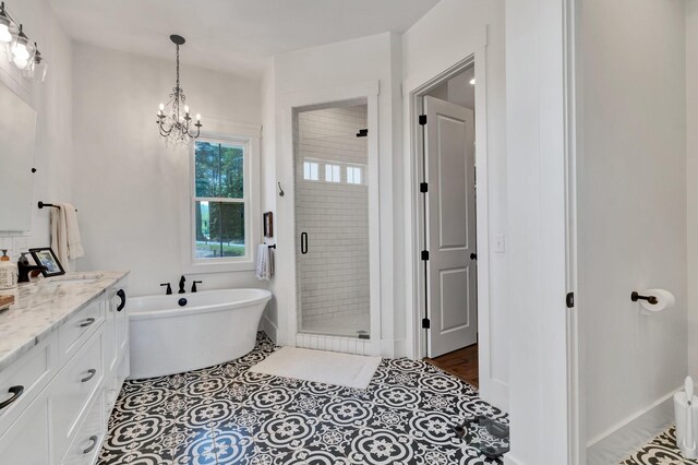 bathroom with tile patterned flooring, vanity, plus walk in shower, and a chandelier