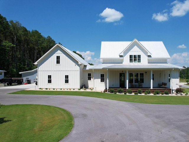 modern farmhouse featuring a front lawn and a porch