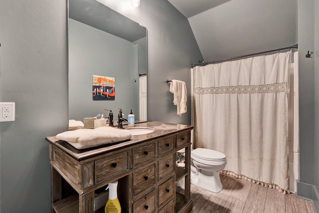 bathroom featuring vanity, wood-type flooring, toilet, curtained shower, and lofted ceiling