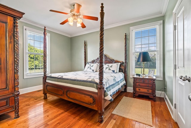 bedroom with hardwood / wood-style floors, ceiling fan, crown molding, and multiple windows