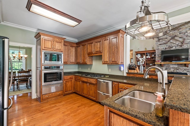 kitchen featuring kitchen peninsula, appliances with stainless steel finishes, decorative light fixtures, and sink