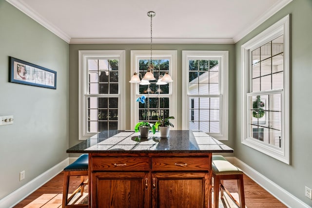 dining space with a notable chandelier, light wood-type flooring, and crown molding