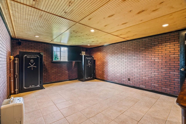 interior space featuring light tile patterned flooring and brick wall