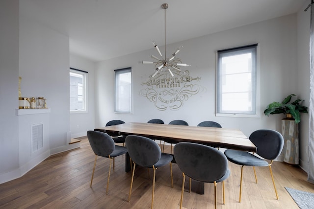 dining space featuring hardwood / wood-style floors and a notable chandelier