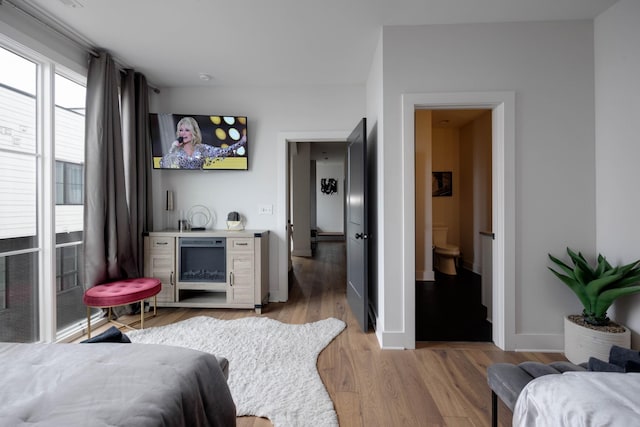 bedroom with light hardwood / wood-style flooring and ensuite bathroom