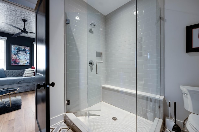 bathroom with hardwood / wood-style flooring, toilet, and a shower with shower door