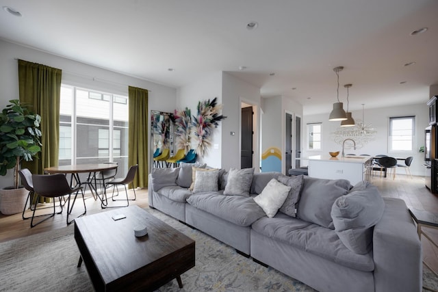 living room featuring sink, light hardwood / wood-style flooring, and a wealth of natural light