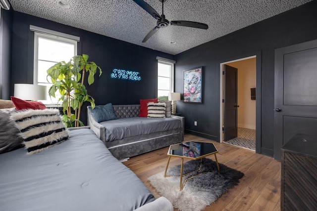 bedroom with hardwood / wood-style floors, a textured ceiling, and ceiling fan