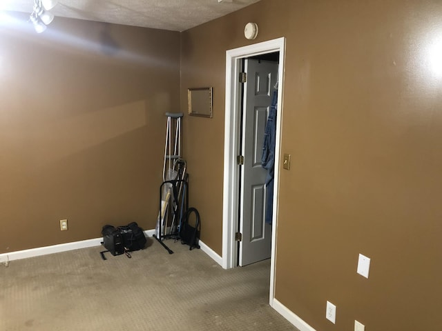 workout area featuring carpet floors and a textured ceiling