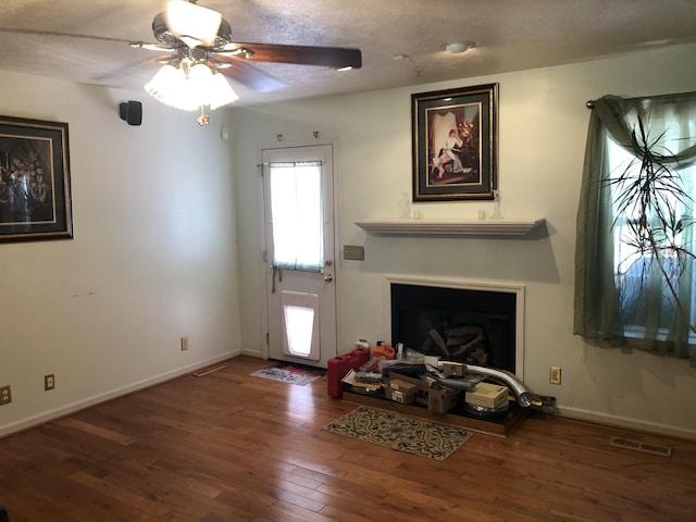 unfurnished living room featuring visible vents, a fireplace, baseboards, and hardwood / wood-style flooring