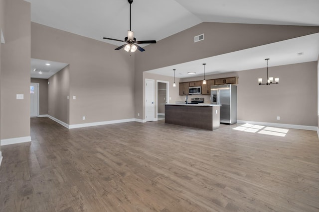 unfurnished living room featuring light wood finished floors, baseboards, visible vents, high vaulted ceiling, and ceiling fan with notable chandelier