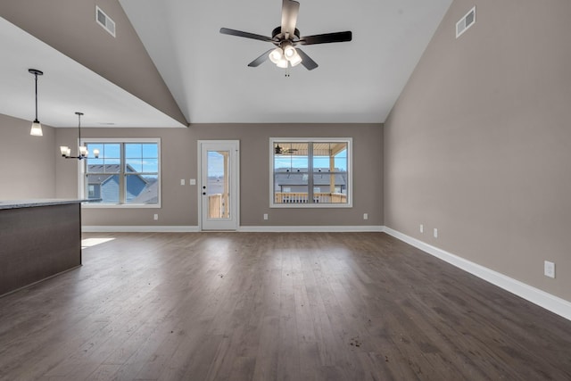 unfurnished living room featuring ceiling fan with notable chandelier, dark wood finished floors, visible vents, and baseboards