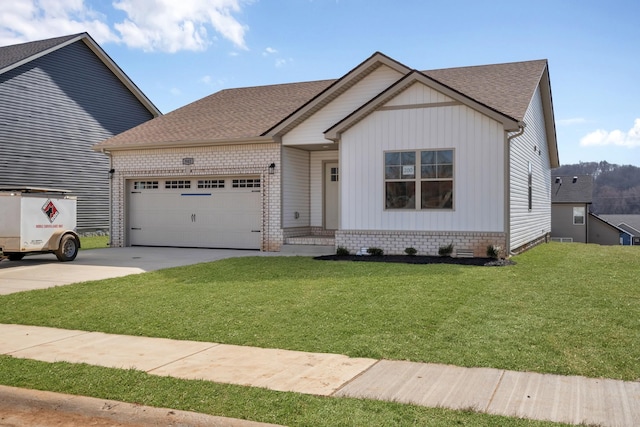 view of front of house with driveway, a shingled roof, an attached garage, a front yard, and brick siding