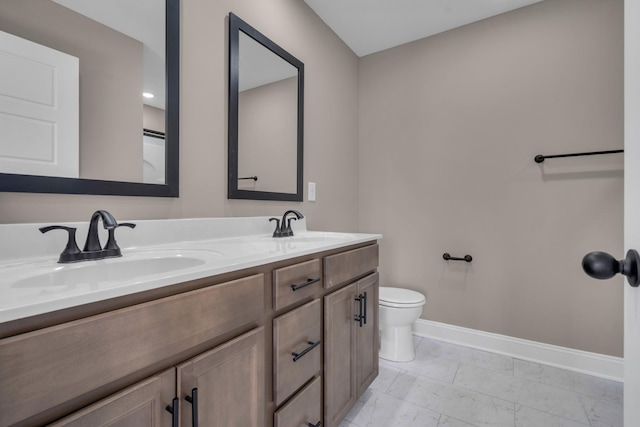 full bath with double vanity, marble finish floor, baseboards, and a sink