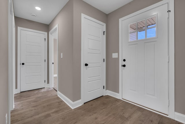 foyer entrance featuring baseboards and light wood finished floors