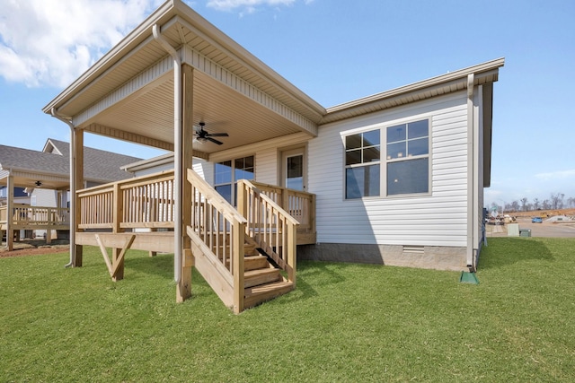 rear view of property featuring ceiling fan, crawl space, a wooden deck, and a lawn