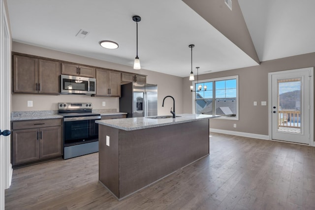 kitchen with stainless steel appliances, a kitchen island with sink, a sink, and wood finished floors