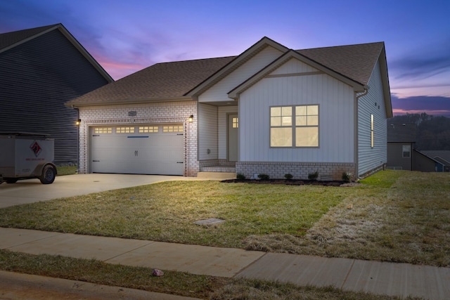 view of front of property with an attached garage, brick siding, concrete driveway, a lawn, and roof with shingles